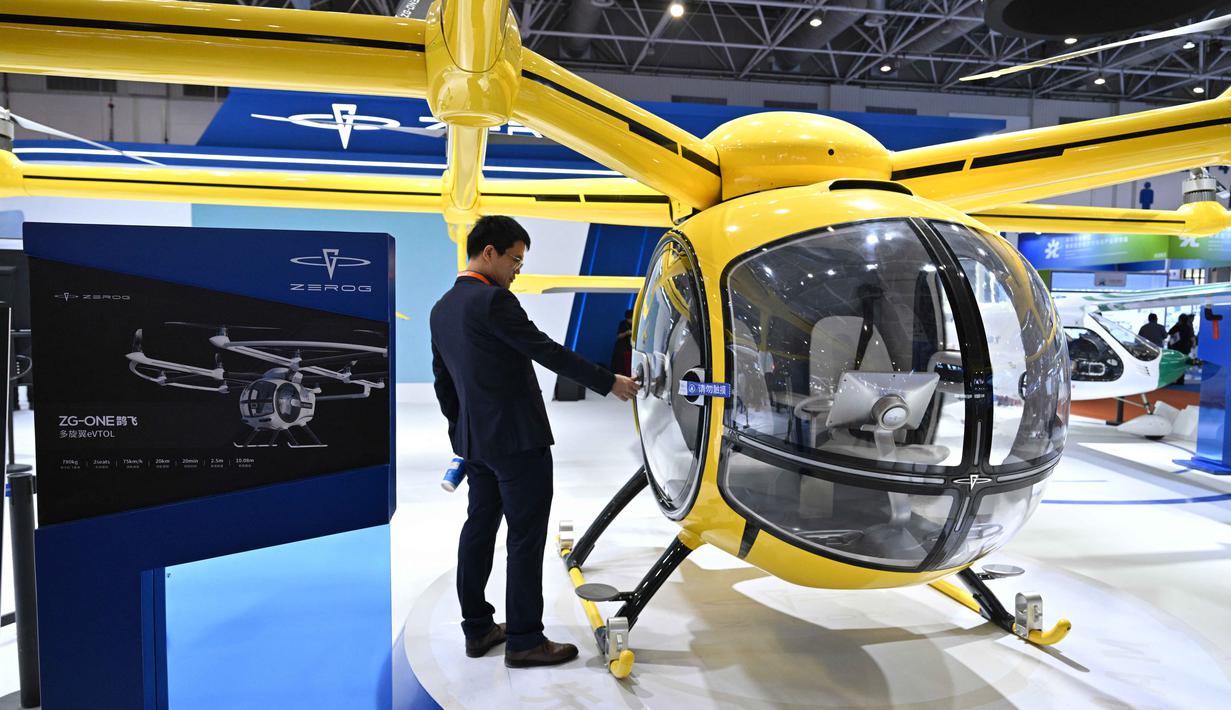 Berlangsung di Zhuhai International Airshow Center, China, perhelatan ini akan berlangsung hingga 30 November 2025 mendatang. Tampak dalam foto, seorang pengunjung terlihat di samping model Zerog eVTOL ZG-ONE di stan Zerog selama Aero Asia 2025 di Zhuhai, Provinsi Guangdong, Tiongkok selatan, pada Kamis 27 November 2025. (Hector RETAMAL/AFP)