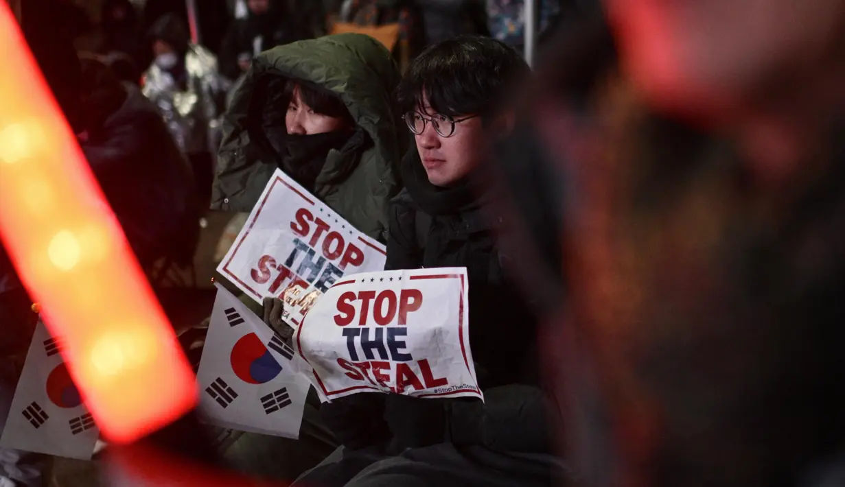 Para pendukung Presiden Korea Selatan yang dimakzulkan, Yoon Suk Yeol, juga membawa plakat bertuliskan "Hentikan Pencurian". (Anthony WALLACE/AFP)