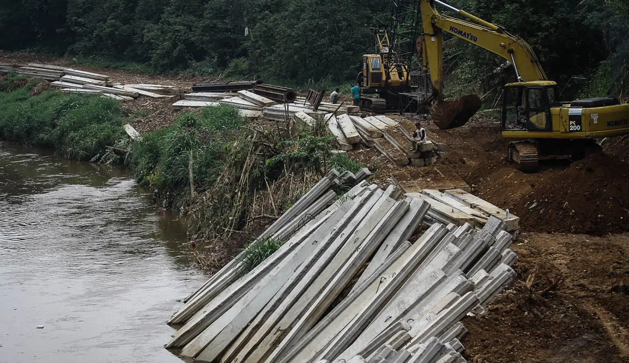 Pekerja dibantu alat berat membuat turap beton dialiran kali Ciliwung-Condet, Jakarta. Foto diambil pada Senin (10/11/2014). (Liputan6.com/Faizal Fanani) 