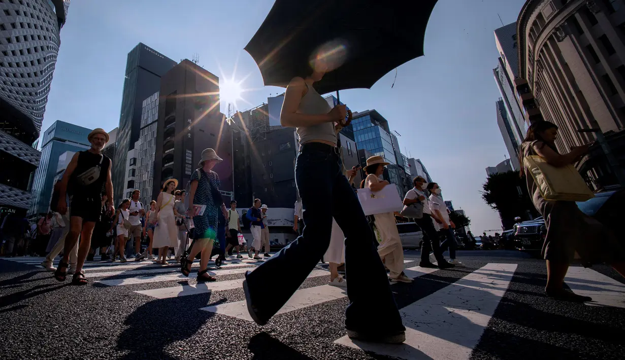 Gelombang panas semakin intens dan sering terjadi di seluruh dunia akibat perubahan iklim. Tampak dalam foto, Orang-orang menyeberang jalan di Tokyo pada 4 Agustus 2025. (Kazuhiro NOGI/AFP)