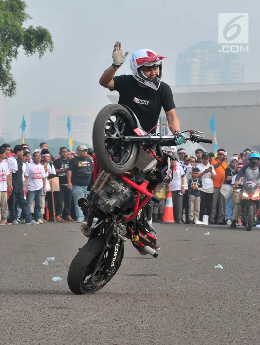 Freestyler melakukan atraksi freestyle sepeda motor saat memeriahkan Festival Damai Millenial Road Safety di Monas, Jakarta, Minggu (23/6/2019). Festival ini menyosialisasikan disiplin berlalu lintas serta merajut persatuan dan kesatuan, khususnya generasi millienial. (merdeka.com/Iqbal Nugroho)
