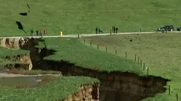 Warga melihat lubang besar yang muncul di peternakan sapi perah dekat Rotorua di Pulau Utara Selandia Baru (2/5). Seorang pekerja menemukan lubang tersebut sebelum fajar ketika mengumpulkan sapi untuk memerah susu. (Newshub via AP Video)