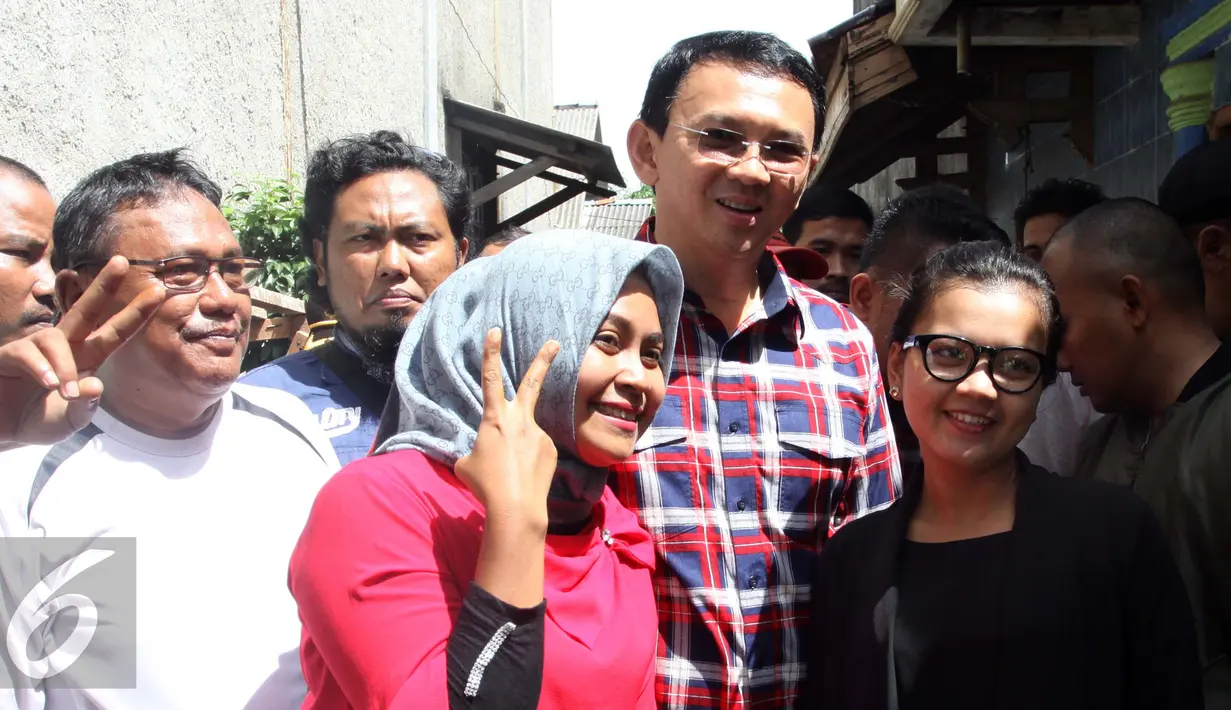 Cagub DKI Jakarta Basuki Tjahaja Purnama atau Ahok berfoto bersama warga saat blusukan di Marunda, Cilincing, Jakarta, Rabu (2/1). Dalam blusukannya Ahok menekankan kepada warga untuk mengurus sertifikat tanah mereka. (Liputan6.com/Gempur M. Surya)