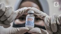 Vaksinator menunjukkan botol vaksin Moderna saat vaksinasi dosis ketiga atau booster kepada tenaga kesehatan di Puskesmas Kecamatan Cilincing, Jakarta Utara, Senin (9/8/2021). Vaksinasi booster tersebut dimaksudkan untuk memberikan proteksi tambahan kepada tenaga kesehatan. (merdeka.com/Iqbal S. Nug