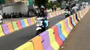 Pengendara motor melintasi di sisi pemisah jalan di Jalan Raya Ragunan sekitar Pasar Minggu, Jakarta, Selasa (24/7). Di kawasan ini pemisah jalan di cat warna warni sehingga terlihat lebih semarak. (Liputan6.com/Helmi Fithriansyah)
