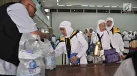 Petugas membagikan air zam-zam untuk jemaah haji Kloter 2 asal Banten di Asrama Haji Pondok Gede, Jakarta, Rabu (29/8). Setiap jemaah mendapatkan lima liter air zam-zam yang dibagikan secara cuma-cuma (Merdeka.com/ Iqbal S. Nugroho)
