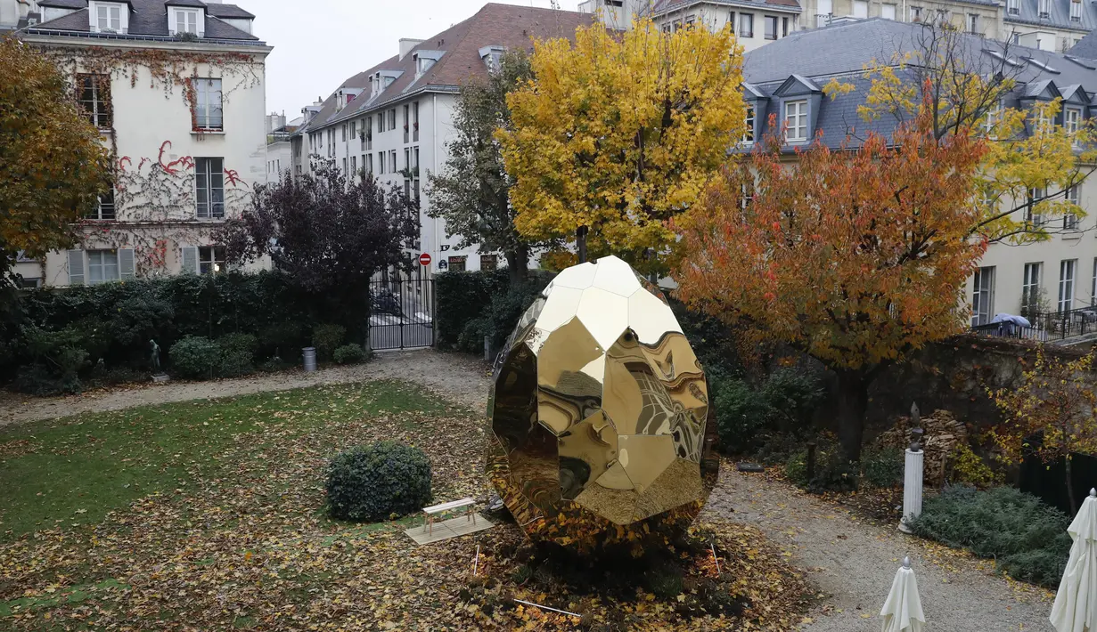 Sebuah fasilitas sauna berbentuk telur raksasa keemasan bernama Solar Egg di halaman Institut Swedia di Paris, Rabu (15/11). Selain sebagai tempat wisata, Solar Egg diharapkan menjadi tempat masyarakat bertemu dan beramah tamah. (PATRICK KOVARIK / AFP)