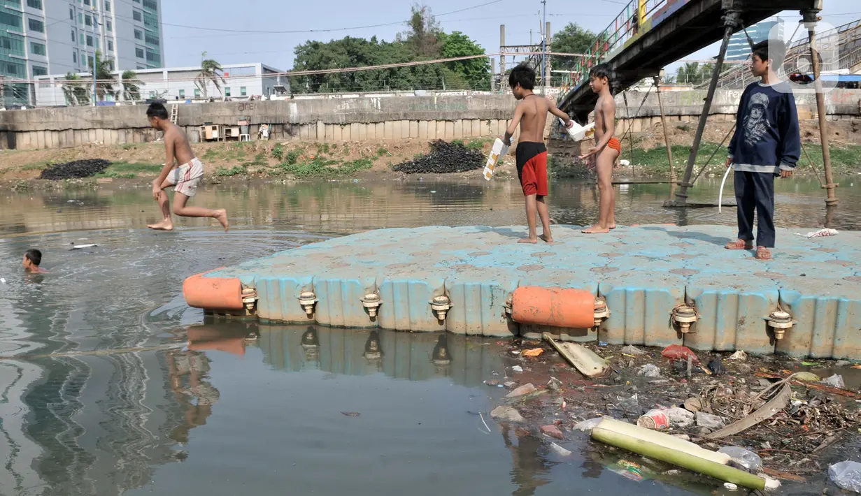 Anak-anak berenang di Kanal Banjir Barat, Jakarta, Minggu (3/11/2019). Banyaknya sampah yang menggenang tidak menghentikan keseruan anak-anak berenang di Kanal Banjir Barat. (merdeka.com/Iqbal Nugroho)