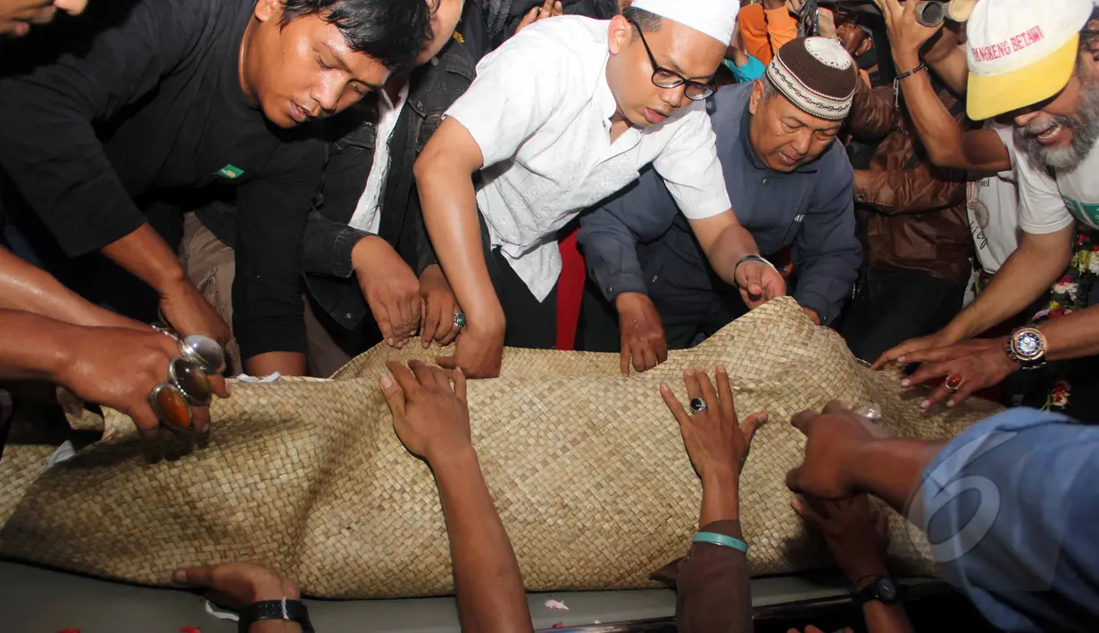 Keluarga dan sahabat saat akan memasukkan jenazah Mpok Nori ke dalam liang lahat di TPU Pondok Ranggon, Jakarta Timur, Jumat (3/4/2015). (Liputan6.com/Helmi Afandi)