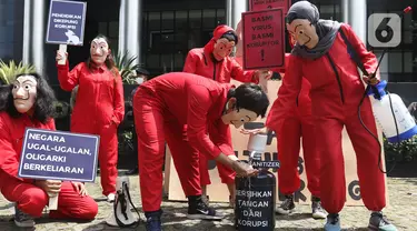 Sejumlah aktivis Indonesia Corruption Watch (ICW) dan Gerakan #BersihkanIndonesia melakukan aksi teatrikal saat unjuk rasa di depan Gedung KPK, Jakarta, Rabu (8/12/2021). Aksi dalam rangka memperingati Hari Anti Korupsi Sedunia pada 9 Desember 2021. (Liputan6.com/Herman Zakharia)