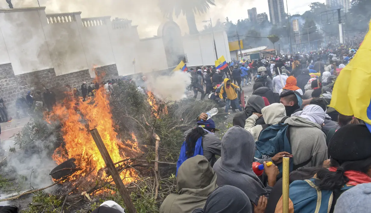 Demonstran membakar pohon di luar gedung parlemen di Quito (8/10/2019). Unjuk rasa ini telah berlangsung selama beberapa hari dan diikuti berbagai elemen termasuk masyarakat adat. (AFP Photo/Martin Bernetti)