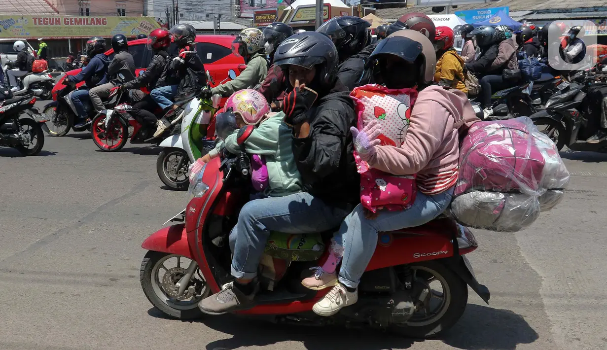 Sejumlah pemudik bersepeda motor melintas di Jalan Raya Brigadir Jenderal Darsono, Cirebon, Jawa Barat, Minggu (7/4/2024). (Liputan6.com/Herman Zakharia)