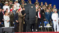 Pengawal melindungi Presiden Venezuela Nicolas Maduro dengan perisai antipeluru saat serangan drone di Caracas, Venezuela, Sabtu (4/8). Dua drone yang dipersenjatai dengan bahan peledak meledak di dekat Presiden Maduro. (Xinhua via AP)