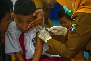 Seorang murid bereaksi saat menerima vaksin difteri di sebuah sekolah dasar di Surabaya pada Selasa 4 November 2025. Dalam pelaksanaannya, tim dari Puskesmas akan mendatangi sekolah sesuai jadwal yang telah ditentukan. Sementara, orang tua/wali murid akan menerima pemberitahuan resmi dari sekolah jauh-jauh hari sebelum imunisasi dilaksanakan. (Juni KRISWANTO/AFP)