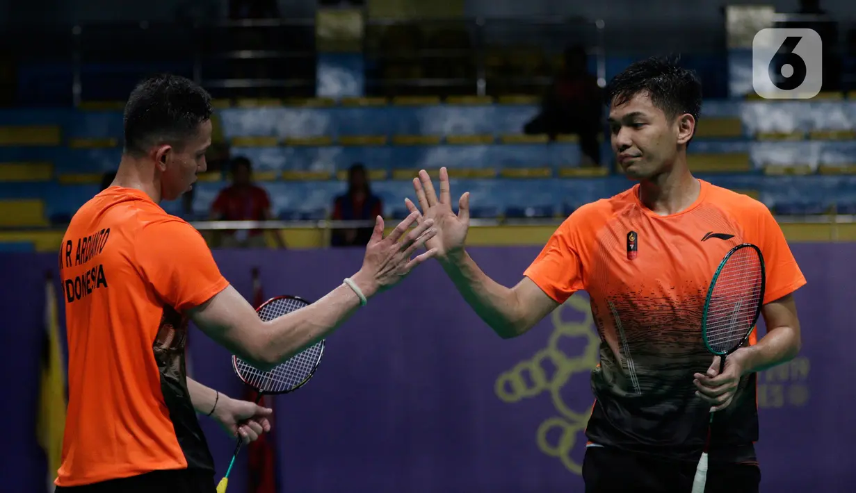 Ganda putra Indonesia, Fajar Alfian/Muhammad Rian Ardianto melakukan tos saat melawan pasangan Malaysia, Aarron Chia/Soh Wooi Yik pada final bulutangkis beregu putra SEA Games 2019 di Multinlupa Sport Center, Rabu (4/12/2019). Fajar / Rian kalah 17-21 dan 13-21. (Bola.com/M Iqbal Ichsan)