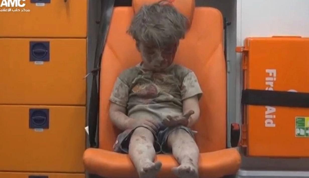 Seorang bocah duduk di dalam ambulans usai diselamatkan dari reruntuhan gedung yang hancur akibat serangan jet tempur milik pemerintah Suriah, Aleppo, Suriah (17/8). (REUTERS)