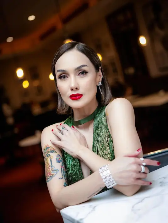 Gaun terbuka ini mengekspos tato wayang yang ada di lengan sebelah kanan [@sarawijayanto]