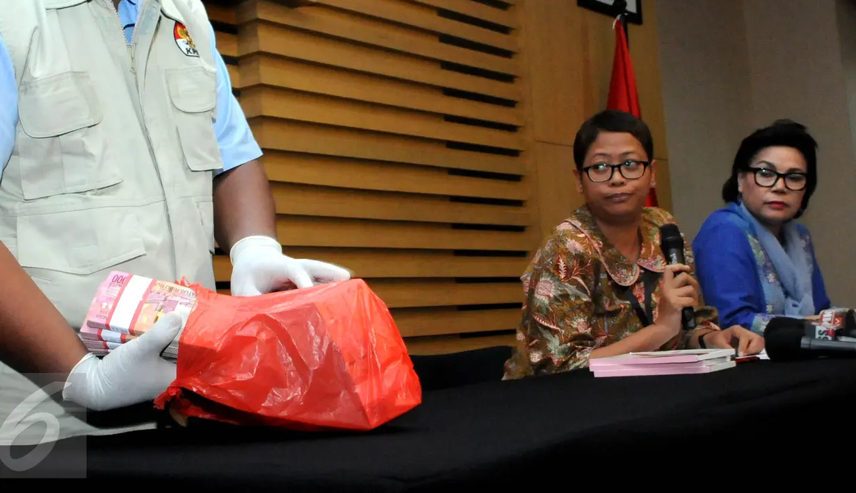 Petugas saat akan menunjukkan barang bukti uang hasil OTT  terkait dugaan suap pengurusan perkara Saipul Jamil, disaksikan Juru Bicara KPK, Yuyuk Andriati dan Wakil Ketua KPK, Basaria Pandjaitan di Jakarta, Kamis (16/6). (Liputan6.com/Helmi Afandi)