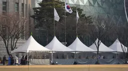 Orang-orang mengantre untuk tes virus corona COVID-19 sambil menjaga jarak sosial di klinik skrining sementara untuk virus corona dekat Balai Kota Seoul, Seoul, Korea Selatan, Rabu (26/1/2022). (AP Photo/Lee Jin-man)