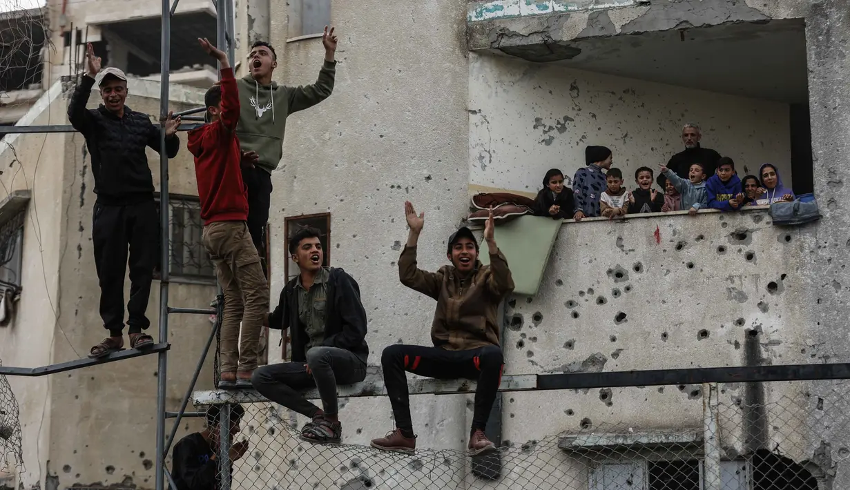 Di tengah kehancuran kota Gaza, peluit wasit, deru gelinding bola dan teriakan dari penonton seakan menjadi suara perlawanan yang terus menggelora. Tampak dalam foto, warga Palestina menyaksikan pertandingan sepak bola lima lawan lima di tengah reruntuhan bangunan yang hancur di Kota Gaza pada Senin 9 Februari 2026. (Omar AL-QATTAA/AFP)