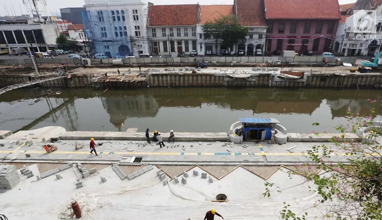 Pekerja menyelesaikan revitalisasi jalur pedestrian di pinggir Kali Krukut kawasan Kota Tua, Jakarta, Rabu (13/9). Revitalisasi dilakukan untuk memberikan nilai tambah pada Kota Tua sebagai salah satu destinasi wisata unggulan. (Liputan6.com/Angga Yuniar)