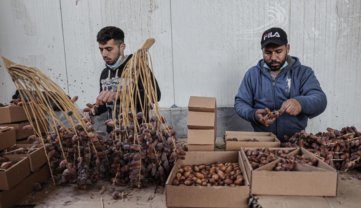 <p>Pekerja Palestina menyortir dan mengemas kurma di sebuah pabrik sebagai persiapan untuk puasa Ramadhan di Khan Yunis di Jalur Gaza selatan pada 19 Maret 2023. (AFP/Said Khatib)</p>