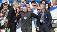 Seorang ofisial pertandingan (tengah) harus memisahkan manajer Arsenal Arsene Wenger (kiri) dan Jose Mourinho (kanan) yang terlibat friksi pada 2014. (AFP/Adrian Dennis)