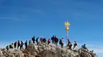 Orang-orang mengantre untuk mencapai puncak salib di puncak gunung tertinggi Jerman, Zugspitze, dekat Garmisch-Partenkirchen, Jerman pada 19 Agustus 2020. Setiap tahunnya gunung dengan ketinggian 2.962 meter tersebut membuat sekitar setengah juta pengunjung terpesona. (AP Photo/Matthias Schrader)