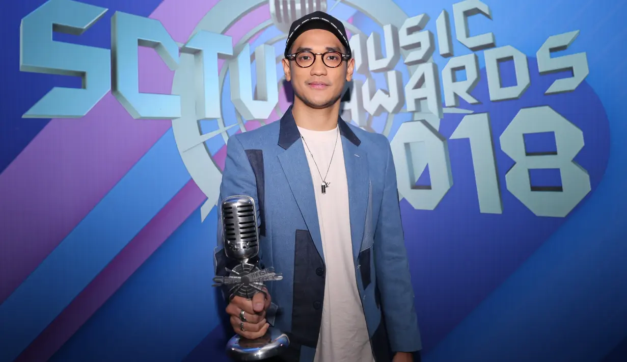 Afgan memegang piala setelah kedua temannya tak bisa hadir. Bagi Afgan, ini merupakan kedua kalinya setelah sebelumnya ia sempat menyabet saat kolaborasi dengan Raisa. (Adrian Putra/Bintang.com)
