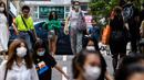 Pejalan kaki mengenakan masker sebagai tindakan pencegahan Covid-19 saat berjalan di Hong Kong (13/5/2020). Dua orang di Hong Kong dinyatakan positif Covid-19, mengakhiri perjalanan 24 hari tanpa kasus baru yang mulai melonggarkan peraturan jarak sosial. (AFP/Anthony Wallace)