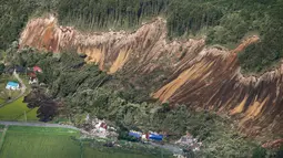 Pemandangan tanah longsor setelah gempa mengguncang Kota Atsuma, Prefektur Hokkaido, Jepang, Kamis (6/9). Gempa menghancurkan sejumlah rumah dan merobohkan tiang listrik. (Kyodo News via AP)