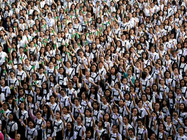 Ribuan siswa St. Scholastica College mengacungkan jari telunjuk "nomor satu" saat menari massal dalam aksi One Billion Rising di Filipina, Senin (15/2). Gerakan ini bentuk kampanye untuk menghentikan kekerasan terhadap perempuan. (AFP PHOTO/Noel CELIS)