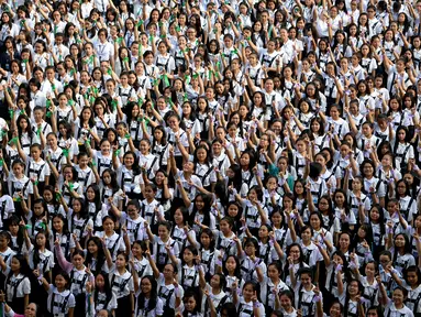 Ribuan siswa St. Scholastica College mengacungkan jari telunjuk "nomor satu" saat menari massal dalam aksi One Billion Rising di Filipina, Senin (15/2). Gerakan ini bentuk kampanye untuk menghentikan kekerasan terhadap perempuan. (AFP PHOTO/Noel CELIS)