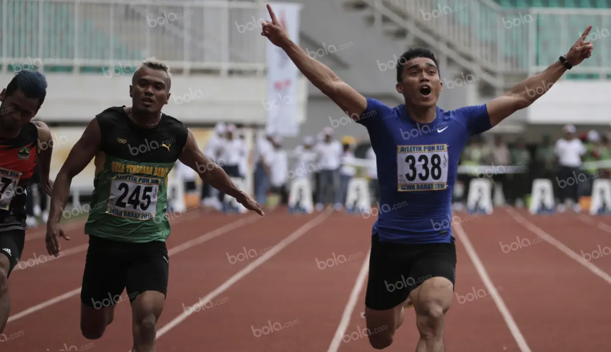 Atlet Sumatra Barat, Yaspi Boby (kanan), meraih emas lari 100m putra PON XIX Jawa Barat 2016 mengalahkan atlet NTB, Iswandi (tengah), dalam final di Stadion Pakansari, Bogor, Kamis (22/9/2016). (Bola.com/Arief Bagus)