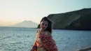 Luna Maya tampil fashionable dengan dress bergaya bohemian di pinggir pantai. Dress halterneck itu memiliki rok maxi dengan outer yang senada [@lunamaya]