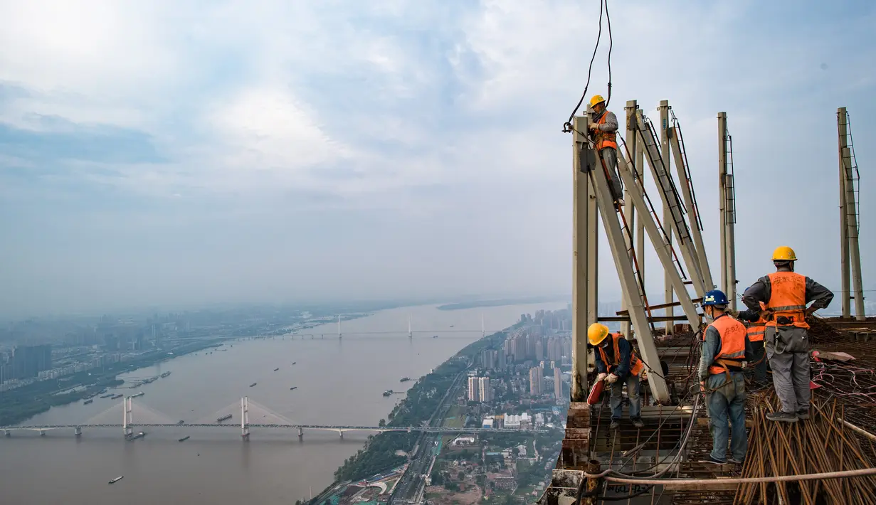 Sejumlah pekerja konstruksi bekerja di ketinggian sekitar 500 meter di lokasi pembangunan sebuah bangunan bertingkat tinggi di Wuhan, Provinsi Hubei, China tengah (11/8/2020). Para pekerja konstruksi harus menghadapi ketinggian dan panasnya udara musim panas. (Xinhua/Xiao Yijiu)