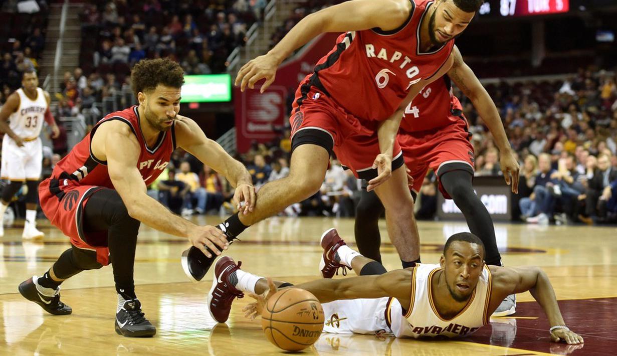 Pemain Cleveland Cavaliers, Markel Brown, terjatuh saat berusaha melewati pemain Toronto Raptors pada laga pramusim NBA di Quicken Loans Arena, Jumat (14/10/2016). (Reuters/David Richard-USA TODAY Sports)