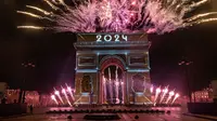 Pertunjukan cahaya diproyeksikan di Arc de Triomphe saat perayaan Tahun Baru di Champs Elysees, Paris, Prancis, Senin (1/1/2024). (AP Photo/Aurelien Morissard)