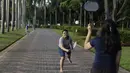 Dua orang warga berusaha memukul kok saat olahraga bulutangkis di Kawasan Monumen Nasional, Jakarta, Rabu (13/2). Monas merupakan salah satu lokasi yang kerap dijadikan ruang olahraga bagi warga ibukota. (Bola.com/M. Iqbal Ichsan)