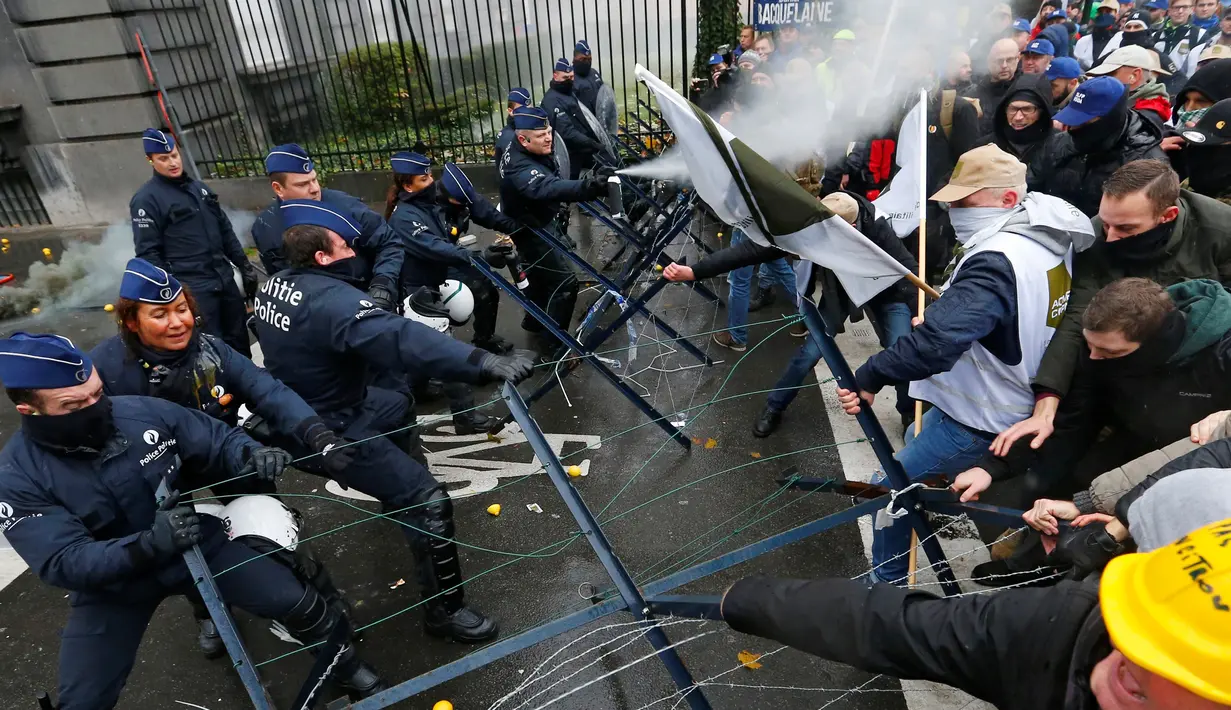 Polisi dan Demonstran terlibat bentrok saat aksi menolak Reformasi Pensiun di Brussels, Belgia, Selasa (15/11). Mereka menolak rencana pemerintah yang akan menaikkan usia pensiun dari 56 menjadi 63 tahun. (REUTERS / Yves Herman)
