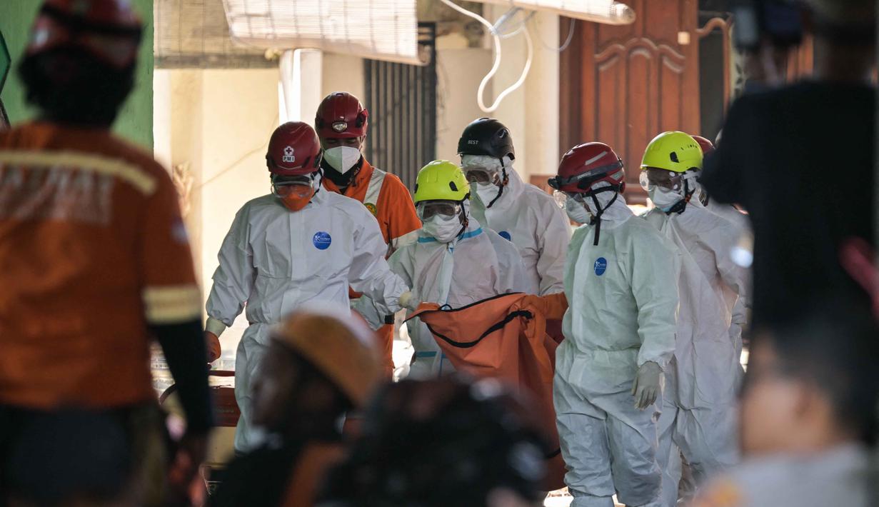 Tim pencari dan penyelamat membawa kantong jenazah dari lokasi runtuhnya bangunan musala di Pondok Pesantren Al Khoziny di Sidoarjo, Jawa Timur, pada 6 Oktober 2025. (JUNI KRISWANTO/AFP)