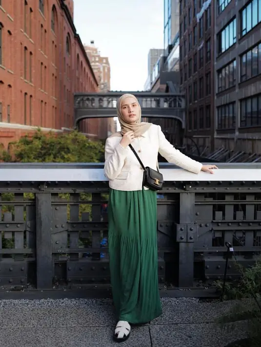 Saat berada di New York untuk hadiri New York Fashion Week 2022, Dwi tampil modis dan elegan memadukan cropped blazer warna putih dengan rok hijau dan hijab warna nude. Penampilannya ini disempurnakan dengan sling bag dan sepatu sandal warna putih. (Instagram/dwihandaanda).