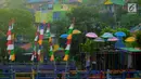 Sejumlah bendera warna-warni dan payung menghiasi Kampung Wonosari di Randusari, Semarang (24/5). Karena berada di bukit tengah kota, rumah-rumah yang dicat warna-warni tampak indah dari kejauhan. (Liputan6.com/Gholib)