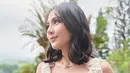 Rambut mediumnya ditata soft curl yang selaras dengan ruffle dress yang ia kenakan [@philipekarunia]