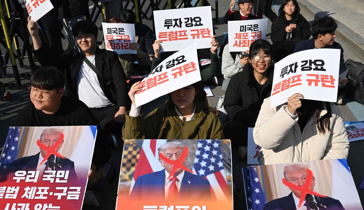 Para demonstran Korea Selatan memegang plakat selama demonstrasi yang mengecam tekanan Presiden AS Donald Trump untuk meningkatkan investasi Korea Selatan di AS, di Gyeongju pada 29 Oktober 2025, menjelang KTT Kerja Sama Ekonomi Asia-Pasifik (APEC). (Jung Yeon-je/AFP)