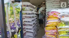 Buruh membawa karung beras di pasar induk beras Cipinang, Jakarta, Sabtu (16/5/2020). Mengantisipasi penyebaran Covid-19 sejumlah kuli dan buruh di Pasar Induk beras Cipinang diberi obat herbal mentah untuk meredakan panas. (Liputan6.com/Herman Zakharia)