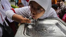 Anak sekolah sedang minum di fasilitas air siap minum (Drinking Fountain) di Museum Nasional, Jakarta, Kamis (8/11). Penyediaan drinking fountain ini merupakan program yang dicanangkan sejak awal tahun 2018. (Liputan6.com/Fery Pradolo)