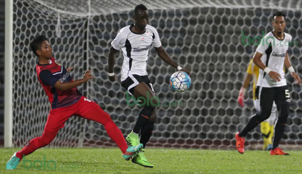 Gelandang  T-Team Malaysia, Makan Konate, menghindari hadangan pemain ATM FA pada laga play-off Malaysia Super League 2016. (Bola.com/Nicklas Hanoatubun)