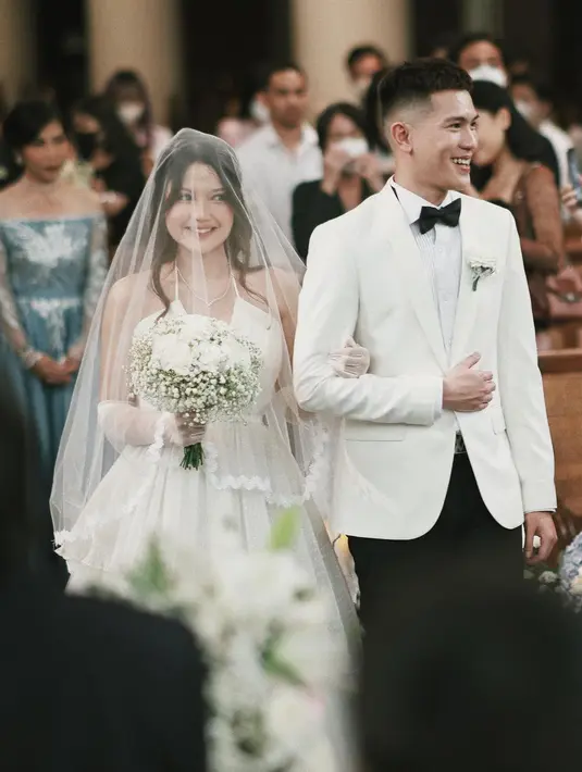 Menikah dengan Julian Jacobs, penyanyi Mirriam Eka tampil dalam balutan gaun berpotongan kerah halter trendi yang memiliki siluet ball gown klasik rancangan Liane Puspita.