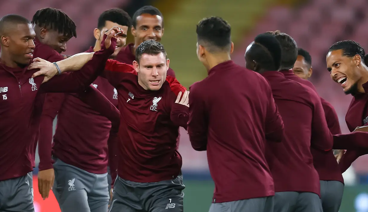 Gelandang Liverpool, James Milner (tengah) bercanda dengan rekan-rekannya selama sesi latihan di stadion San Paolo di Naples, Italia (2/10). Liverpool akan bertanding melawan Napoli pada grup C Liga Champions. (AFP Photo/Carlo Hermann)